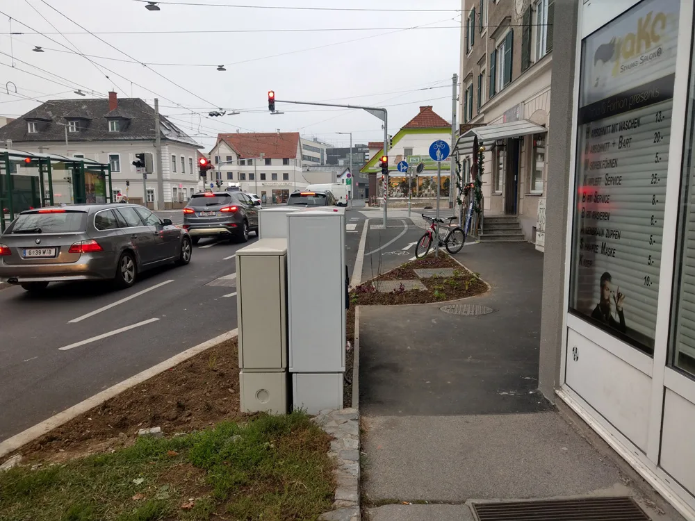 bild_3_elektrokaesten_im_gruenraum_und_um_die_ecke_gefuehrter_gehweg.jpg