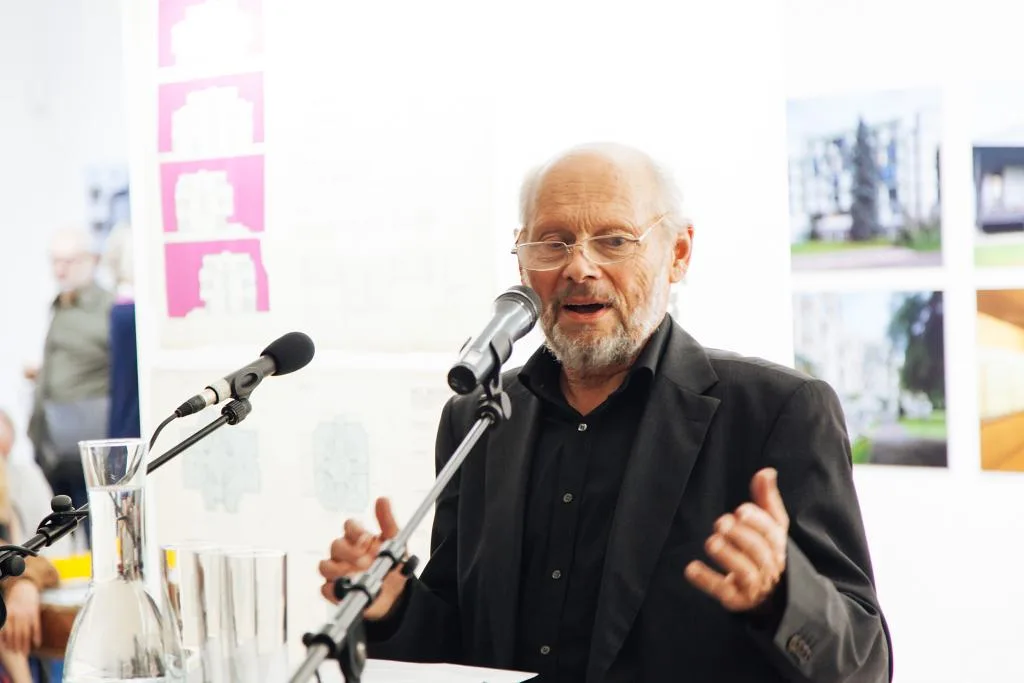Ein älterer Mann spricht in zwei Mikrofone