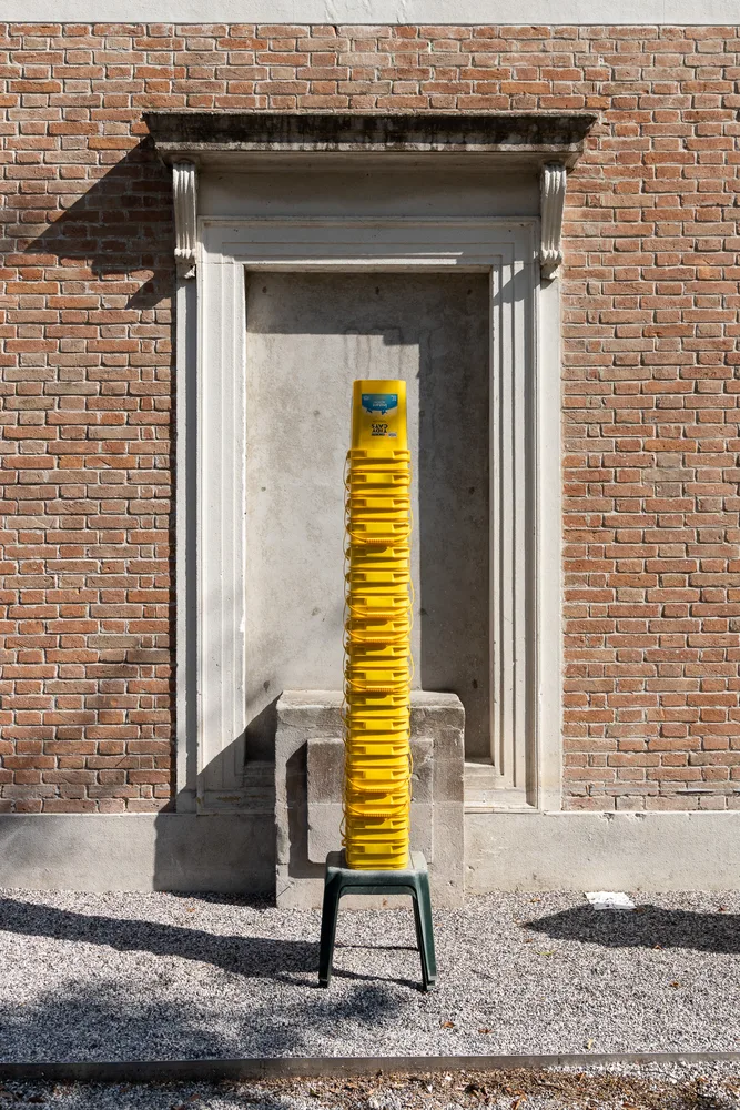 Gelbe Massenprodukte aus Kunststoff gestapelt auf der Architekturbiennale 2023