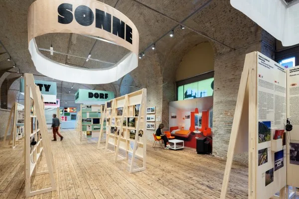 Ausstellungshalle mit Ausstellungspanelen aus Holz, ein Banner mit der Aufschrift Sonne