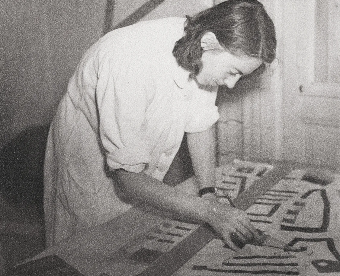 Foto einer Frau, die an einer Zeichnung auf einem Tisch arbeitet