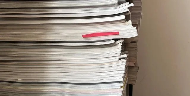 Zeitschriftenstapel mit rotem Mascherl