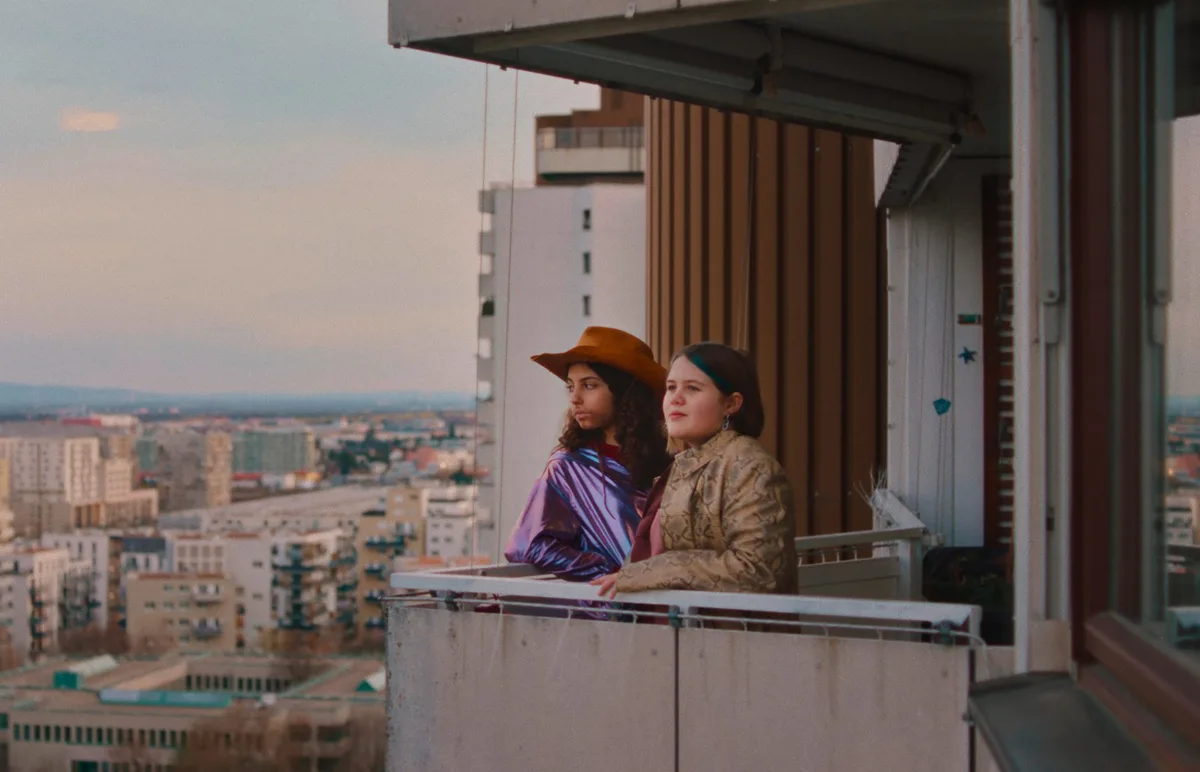 Zwei Mädchen auf einem Balkon, Szene aus Wenn du Angst hast, nimmst du dein Herz in den Mund und lächelst, diagonale '25, © Nikolaus Geyrhalter Filmproduktion