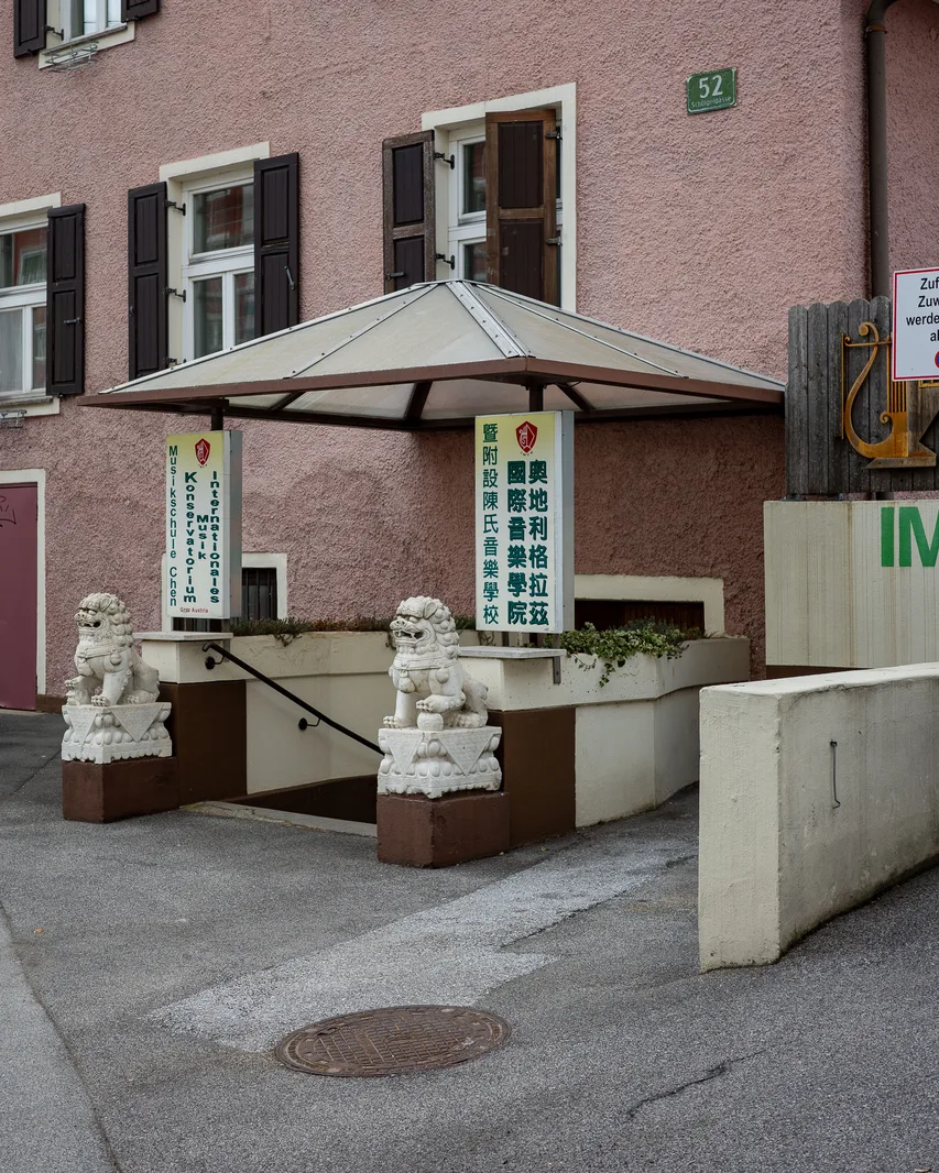 Löwenfiguren vor einem pinken Gebäude