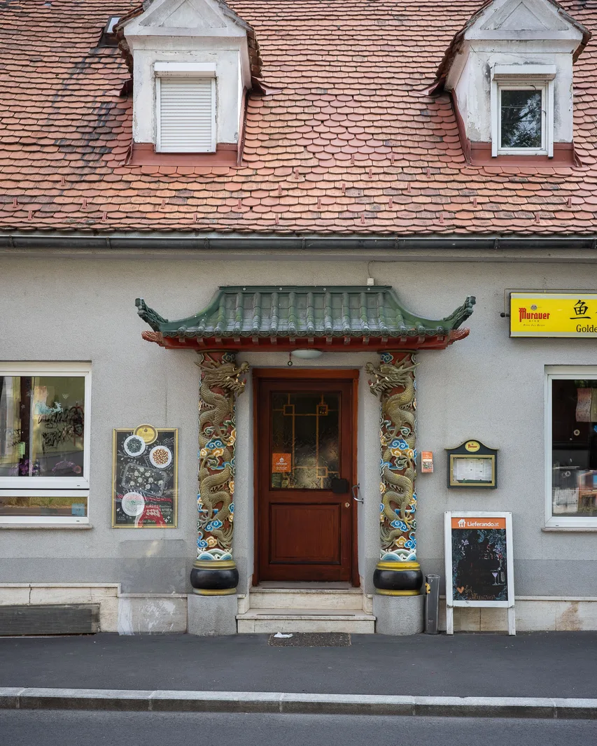 Traditionell-chinesisch angehauchtes Portal auf einem grauen Gebäude