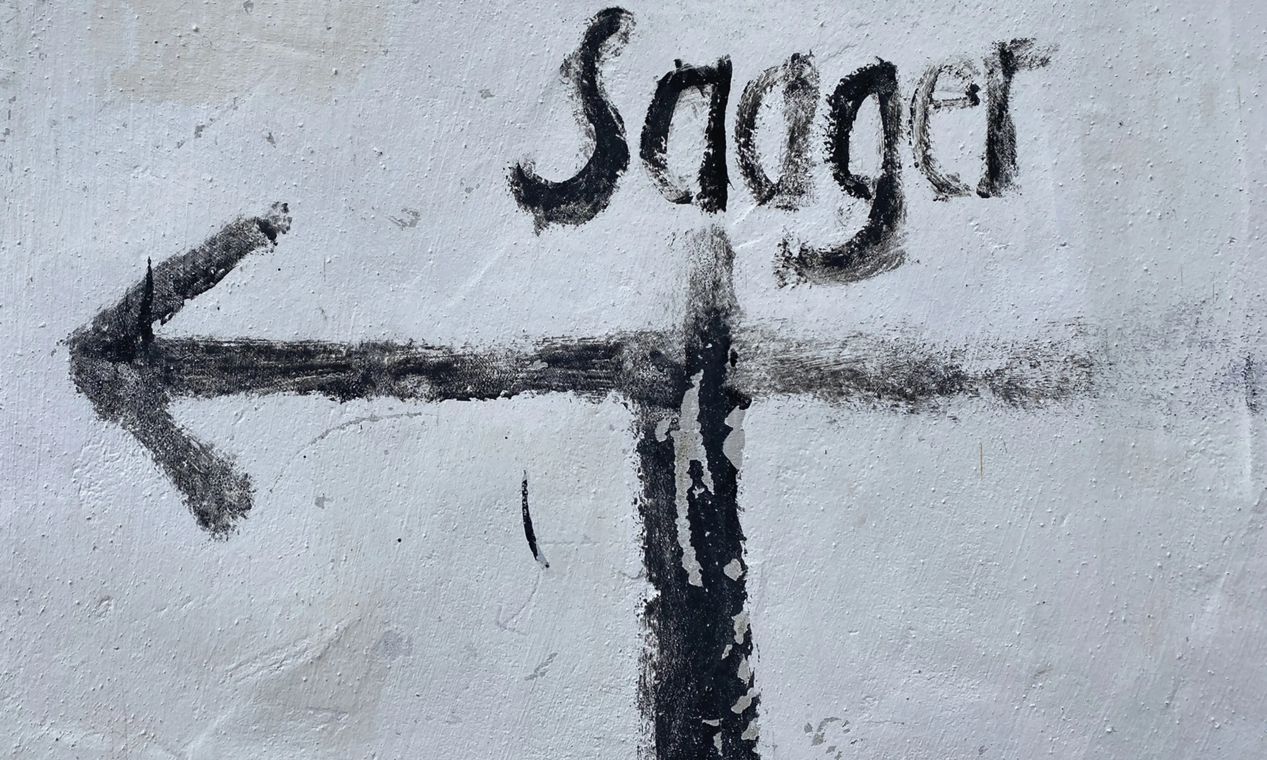 Bild einer weißen Wand mit der schwarzen Aufschrift Saager