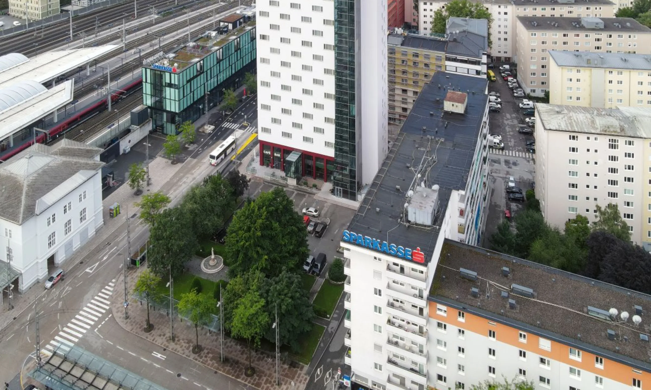 Stadtlandschaft aus Vogelperspektive, im Vordergrund ein Hochhaus