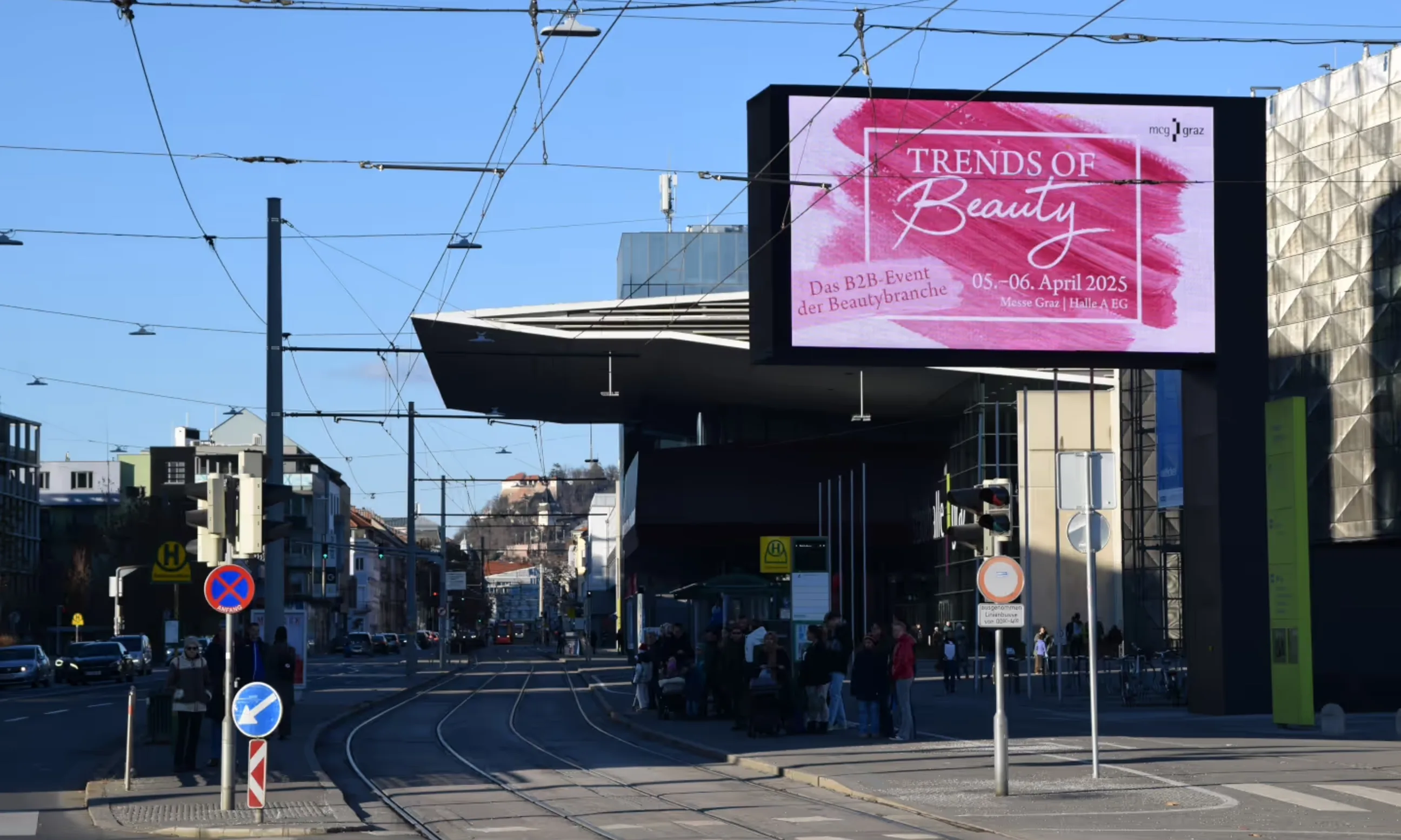 Straßenraum, im Vordergrund ein großes digitales Werbepanel