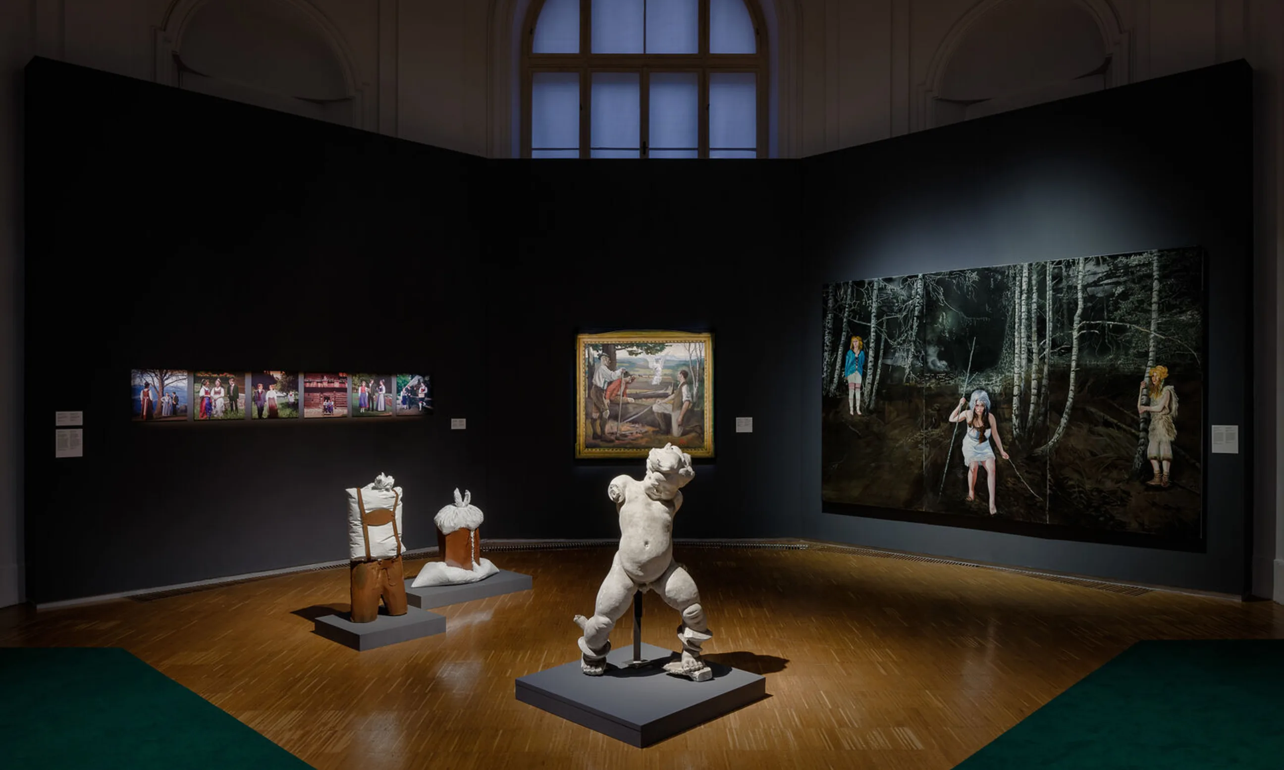 Ausstellungsgalerie; im Vordergrund ein Putto aus Stein, im Hintergrund diverse Gemälde und Photographien