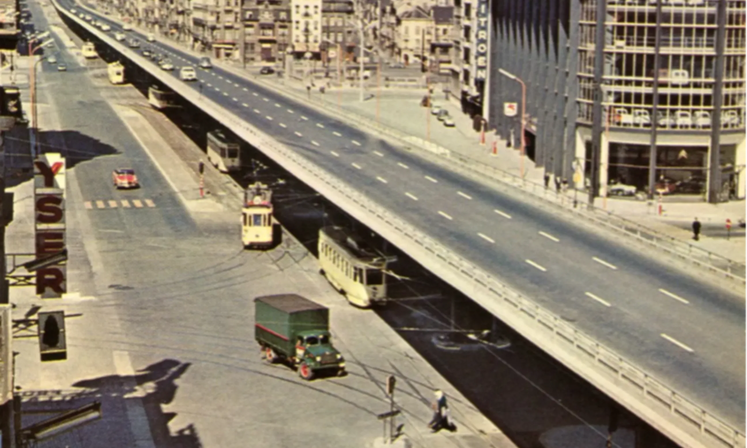Abbildung eines urbanen Boulevards mit regem Verkehr, im Hintergrund eine Stadtdachlandschaft