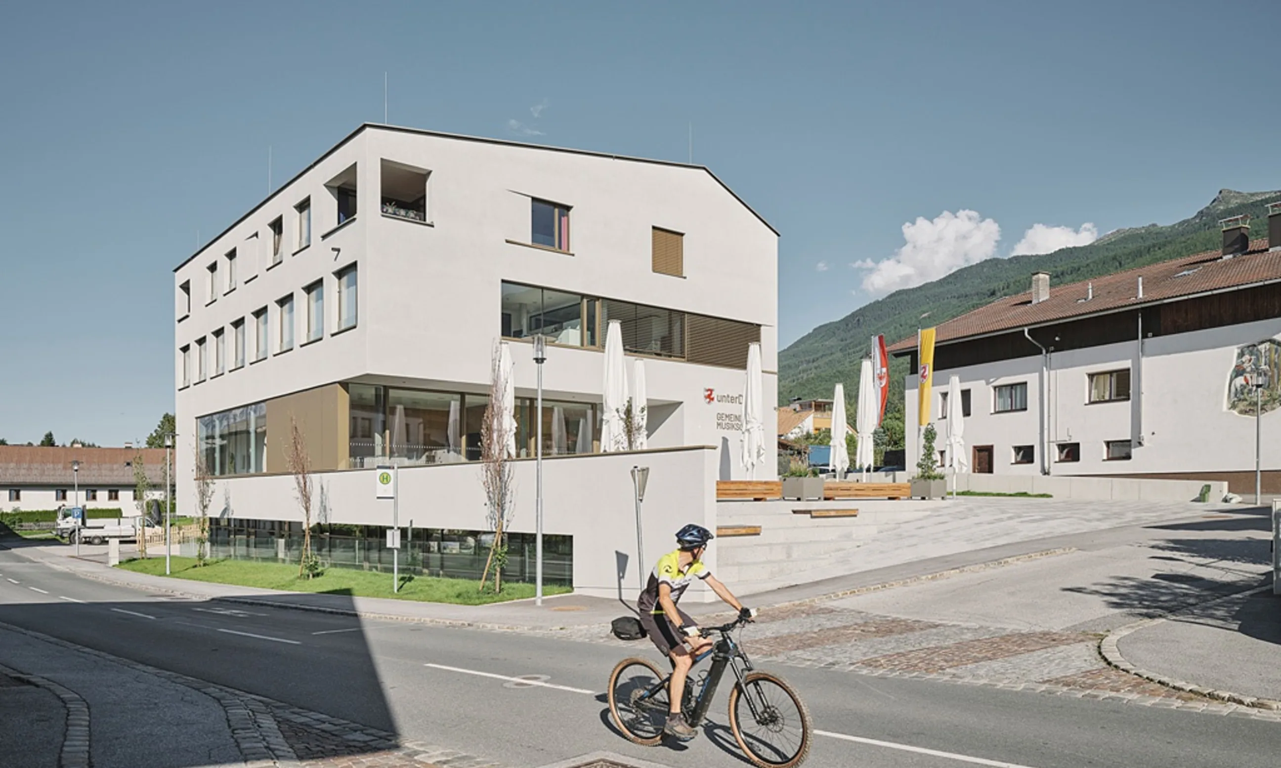 Ein Solitär in eine Dorflandschaft eingebettet. Weiße Fassade, viergeschossig, Holzfenster