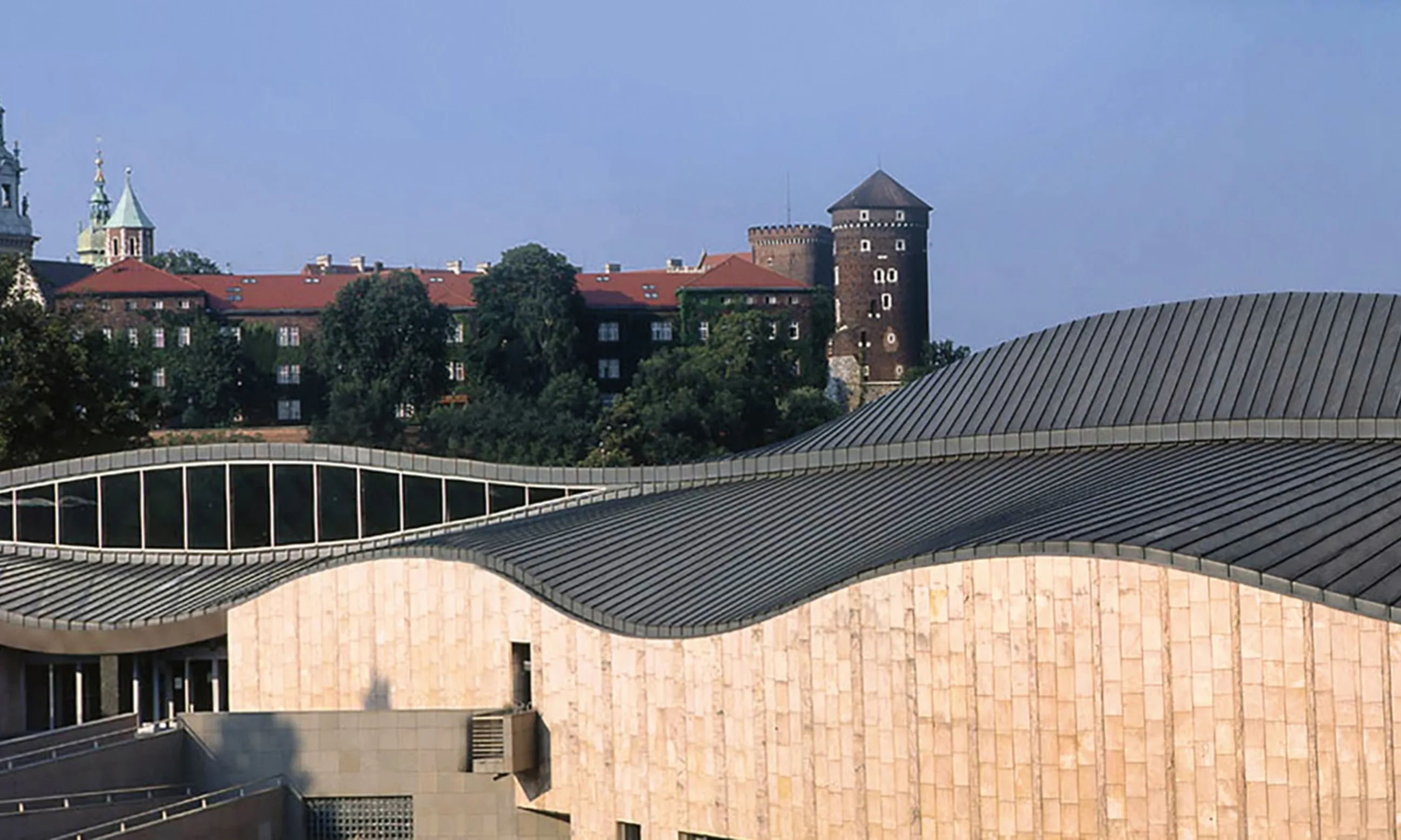 Bild eines Gebäudes von außen. Rosa Steifassade und gewelltes, verzinktes Dach