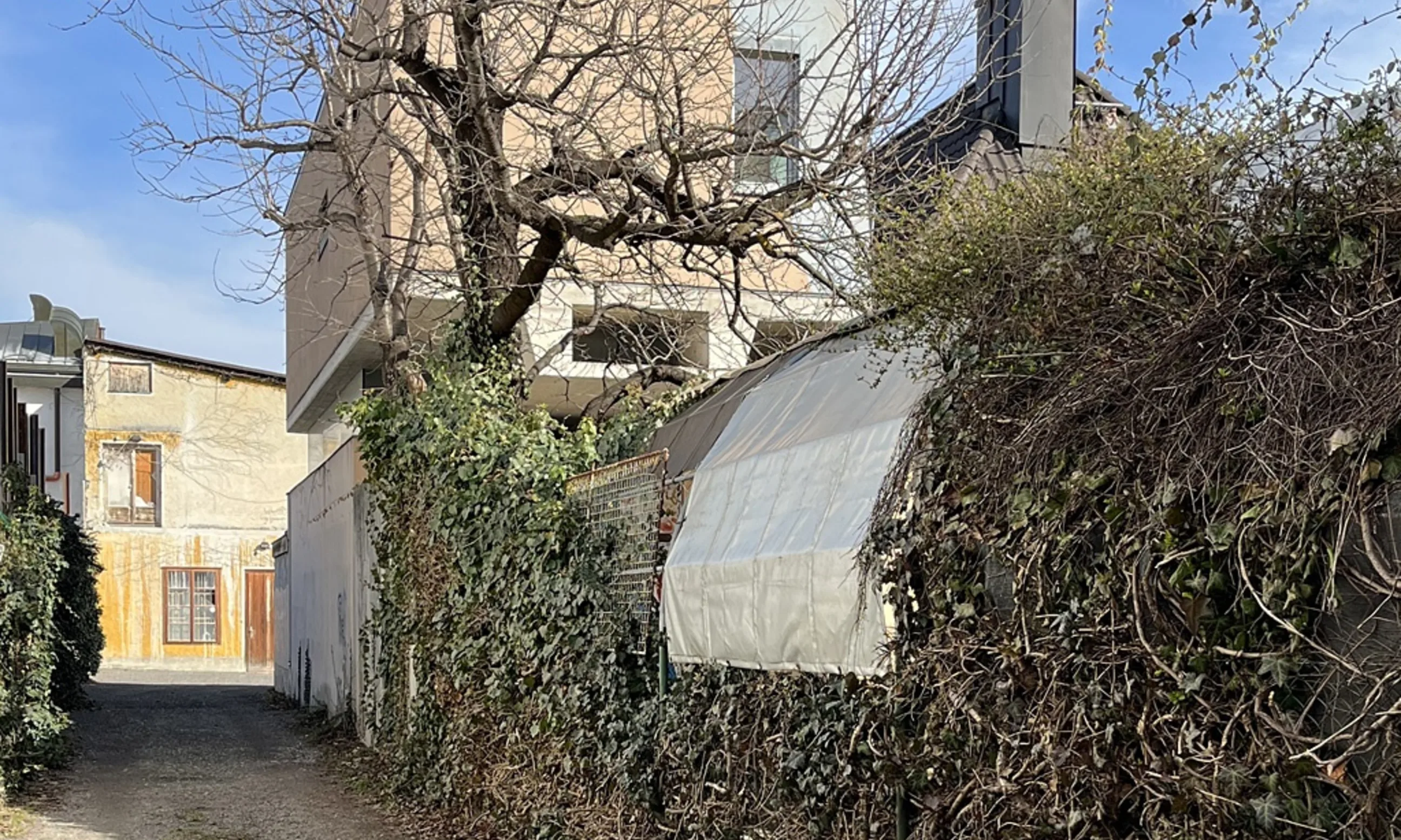 Mehrgeschossiges Wohngebäude mit Garten und Hecke