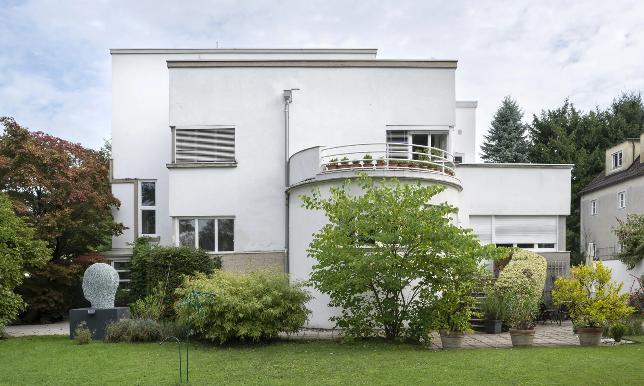 Ein weißes Einfamilienhaus in einer grünen Landschaft