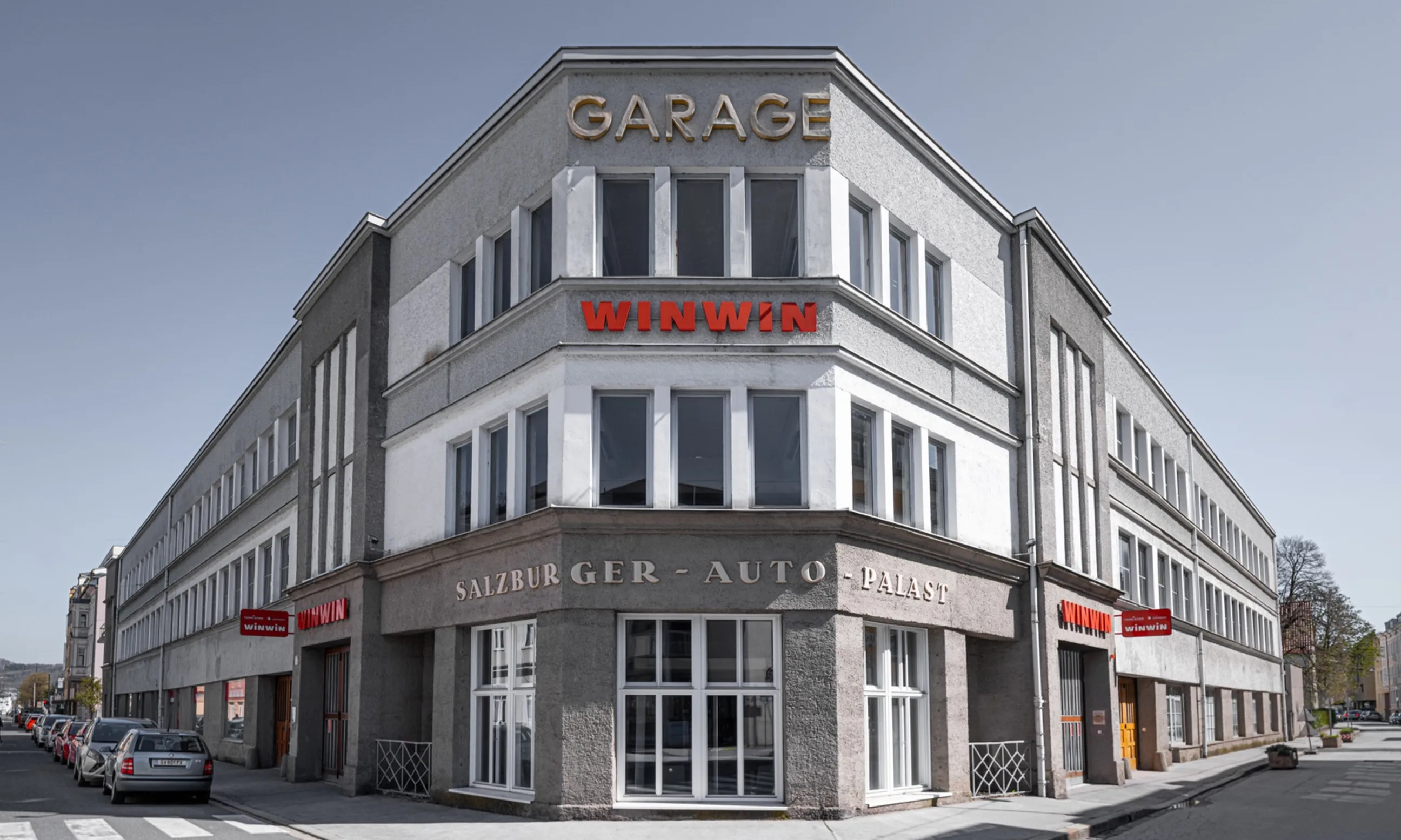 Ein weiß-graues Gebäude an einer Straßenecke. Prominent im Vordergrund die Aufschrift Salzburger Autopalast