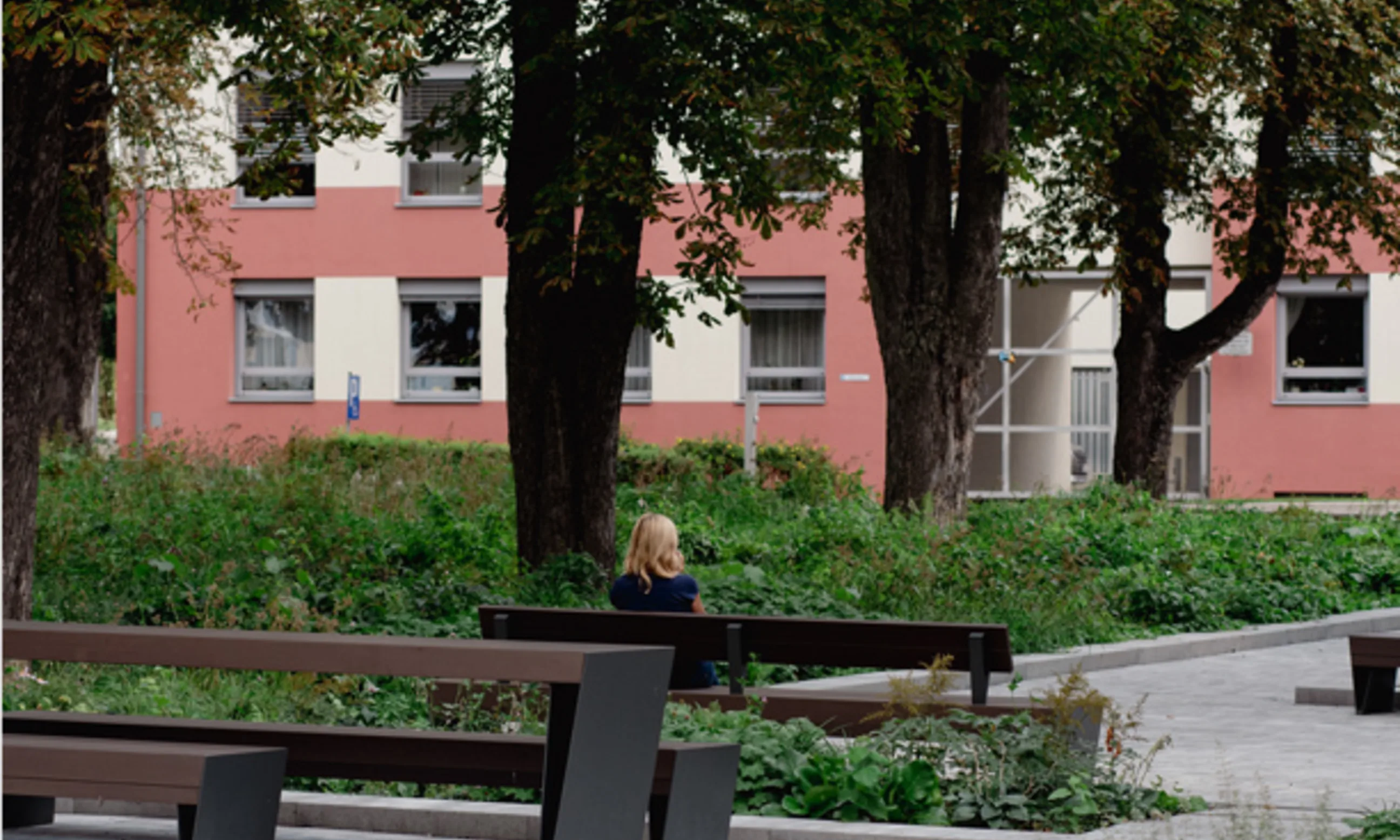 Eine Person sitzt allein auf einer Bank im Park