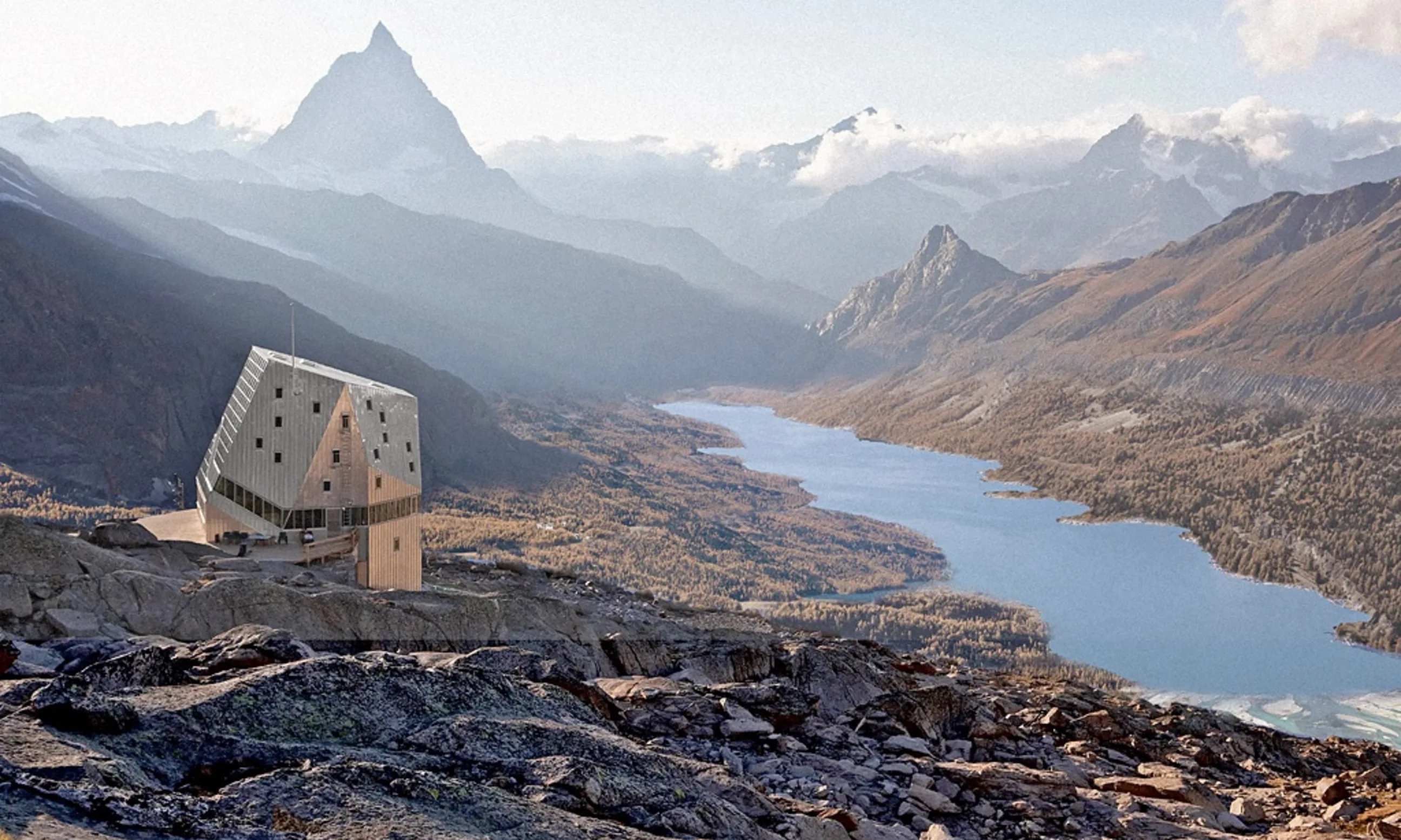 Eine alpine Hütte an einer Bergkippe, im Hintergrund ein Tal mit See sowie eine Berglandschaft