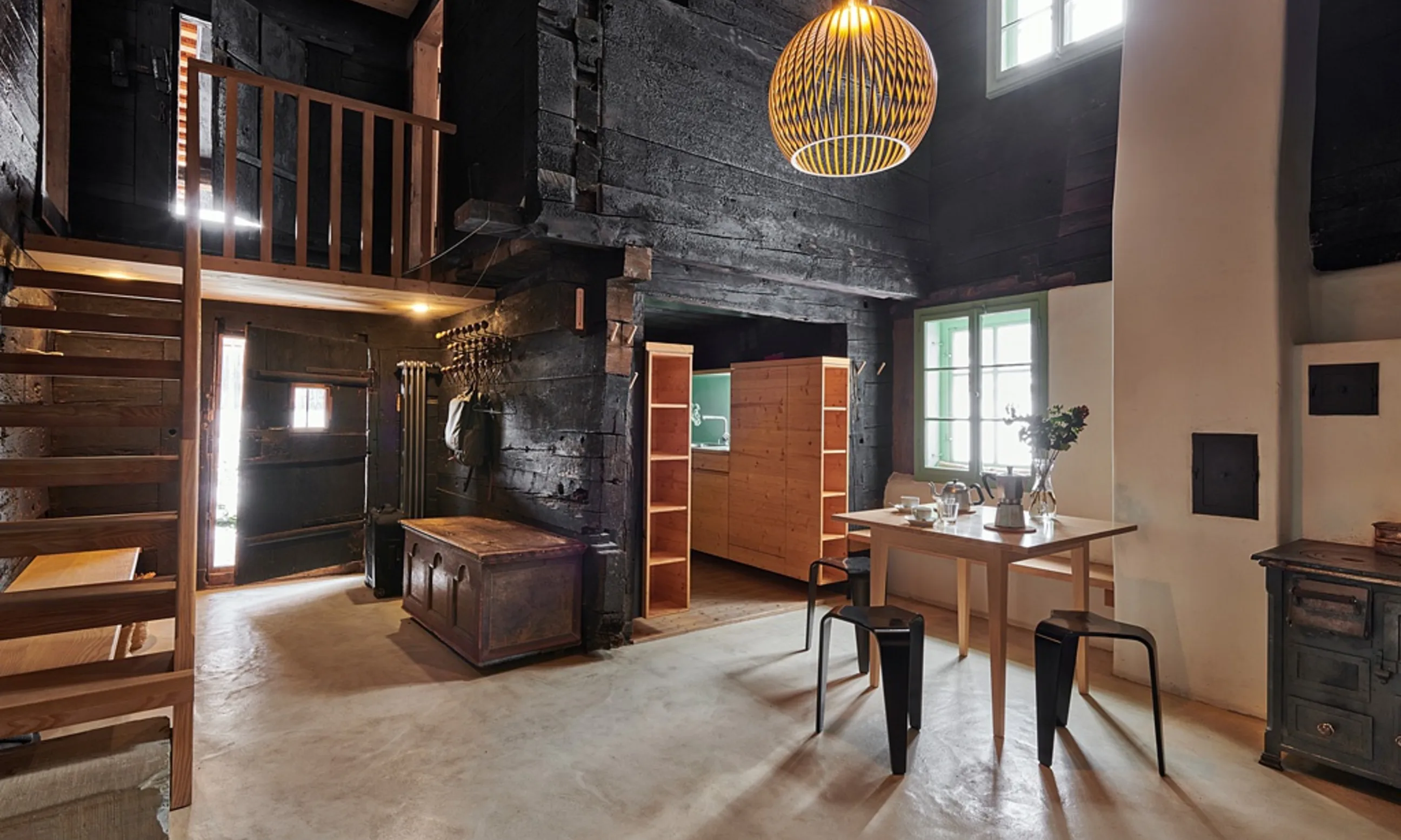 Photographie eines Innenraumes mit Holzbekleidung und Betonboden