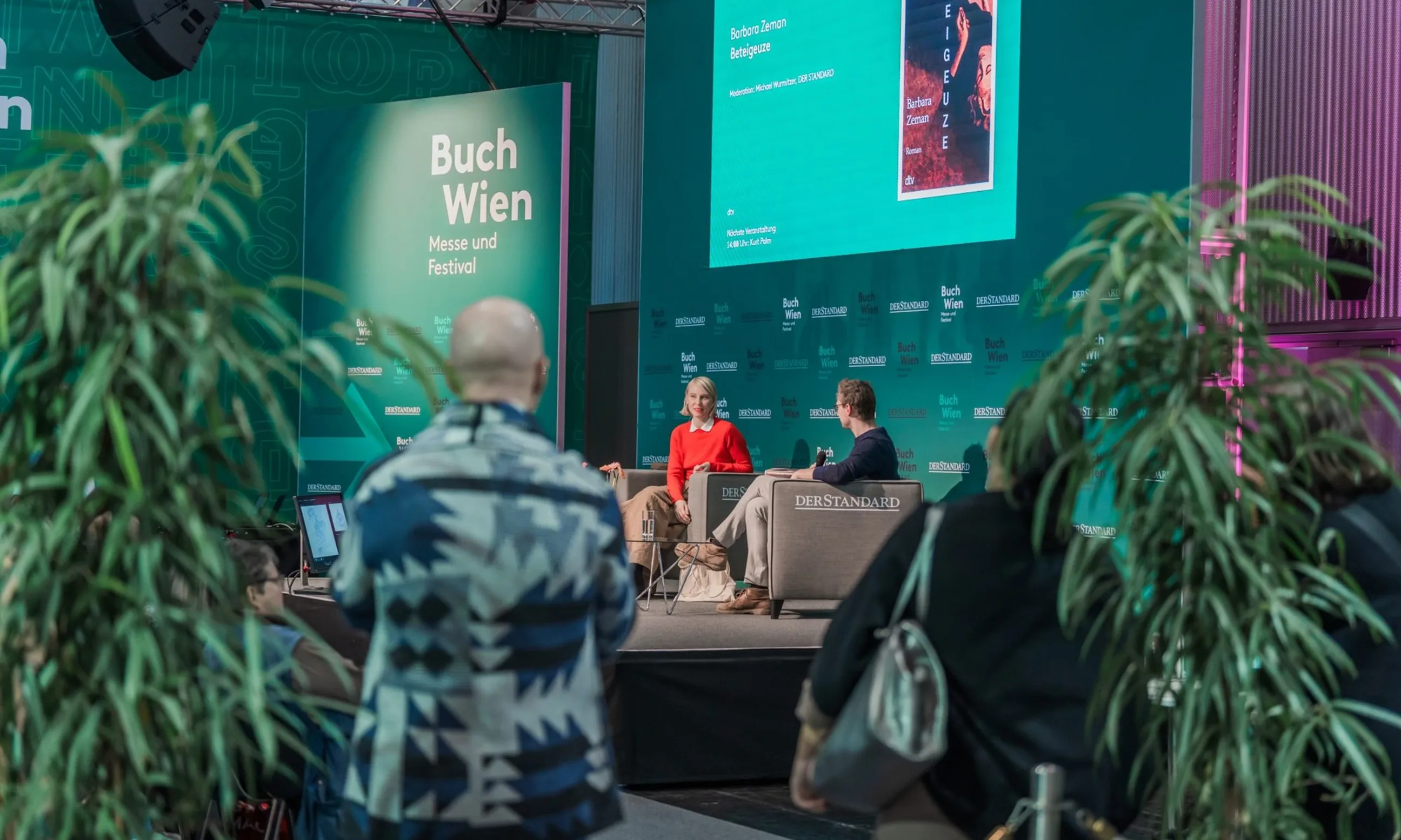 Zwei Personen diskutieren auf einer Bühne