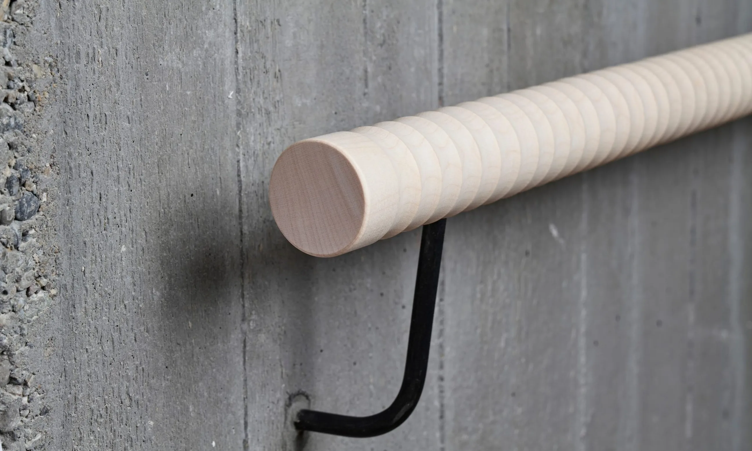 Bild eines Handlaufs aus Holz, befestigt an eine Betonwand