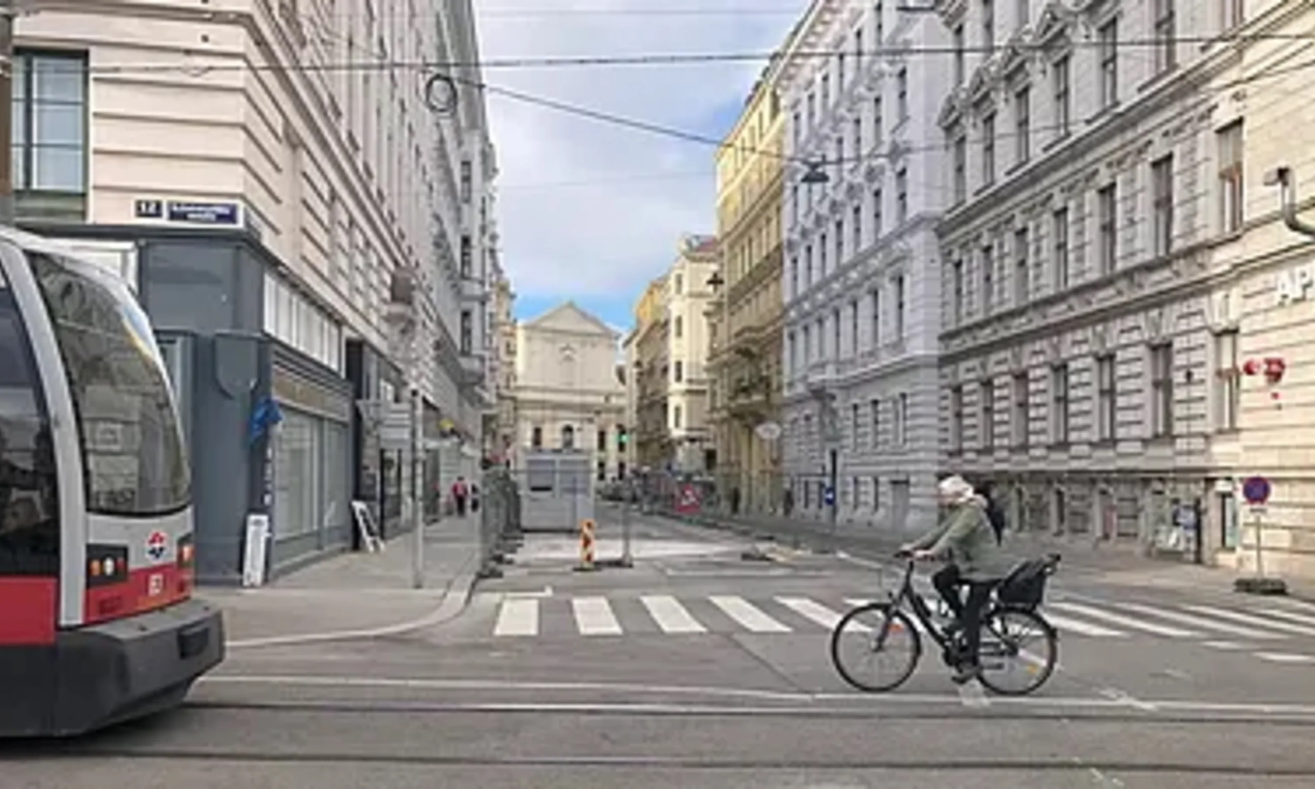 Photo einer Straße, links eine Bim, rechts ein Fahrrad