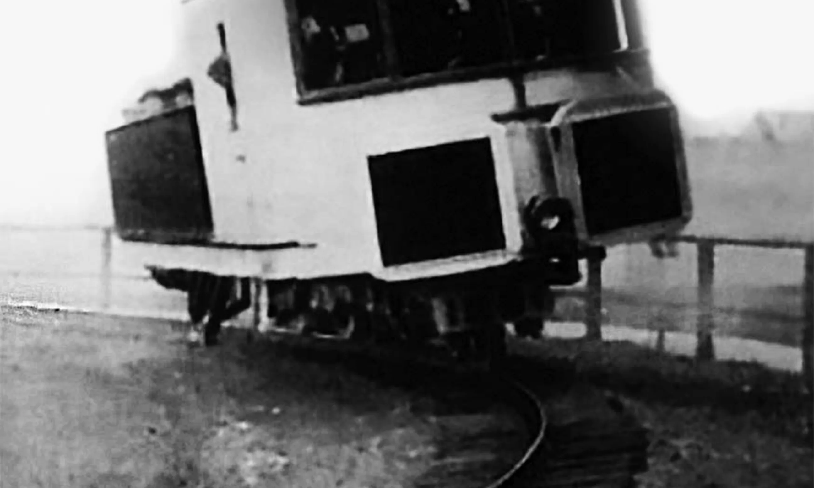 Schwarz-weißes Photo eines Schienenfahrzeugs mit einem Fahrgleis