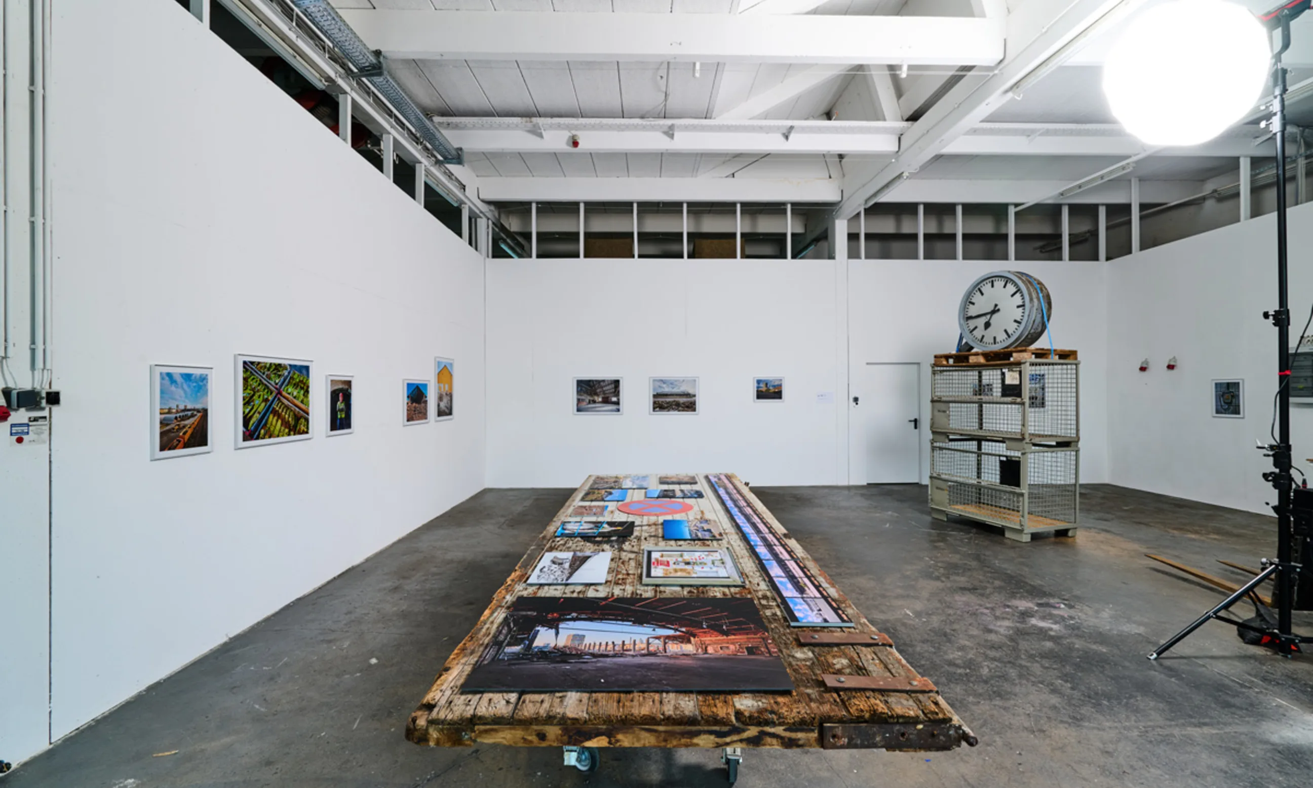 Ausstellungshalle mit Photos und Exponaten auf Tischen und Wänden