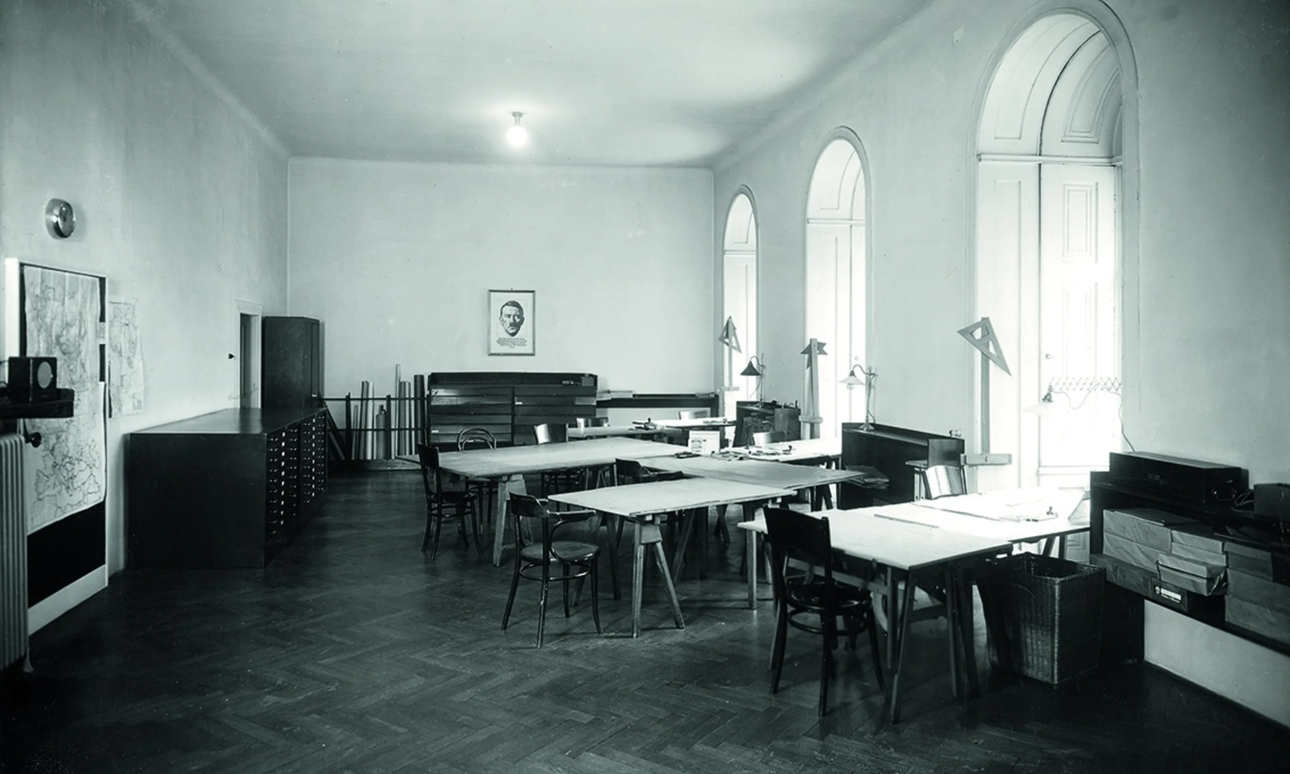 Schwarz-Weiß Photo eines Arbeitsraums mit großen Zeichentischen