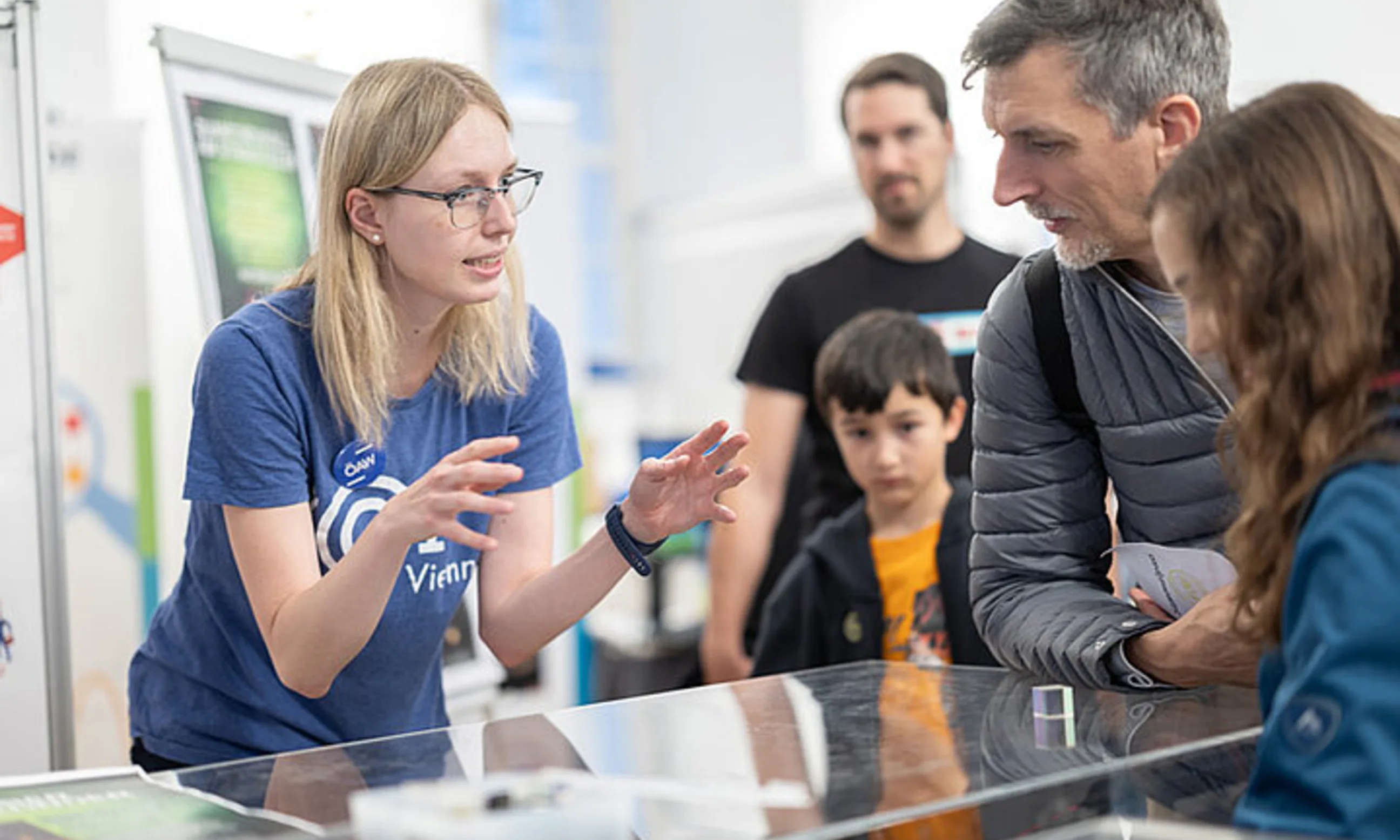 Photo einer Familie rund um einen Glastisch versammelt, eine Person spricht