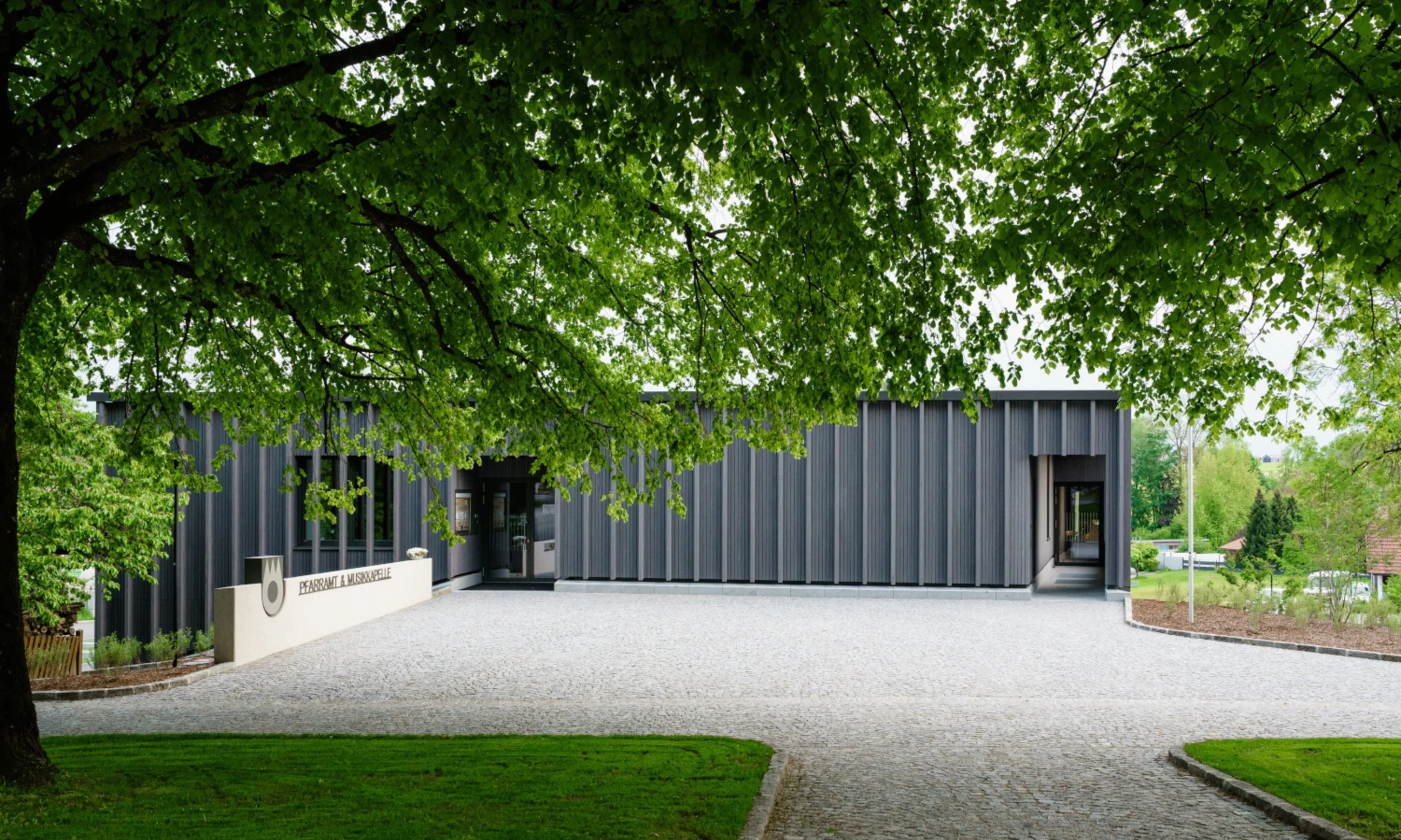 Photo eines Gebäudes mit Holzfassade in einem Garten eigebettet