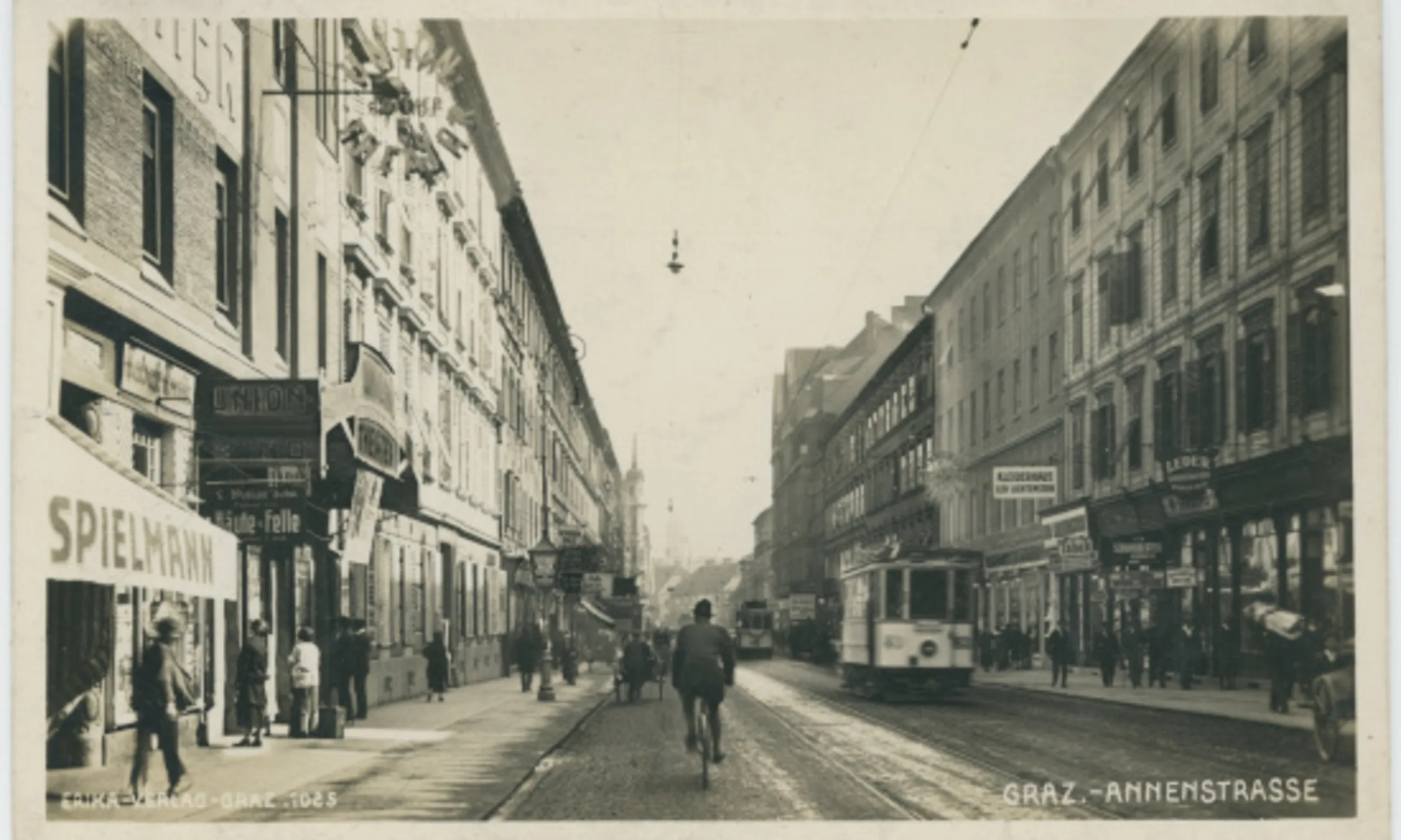 Historische Photoaufnahme eines breiten Straßenzuges mit Gebäuden links und rechts