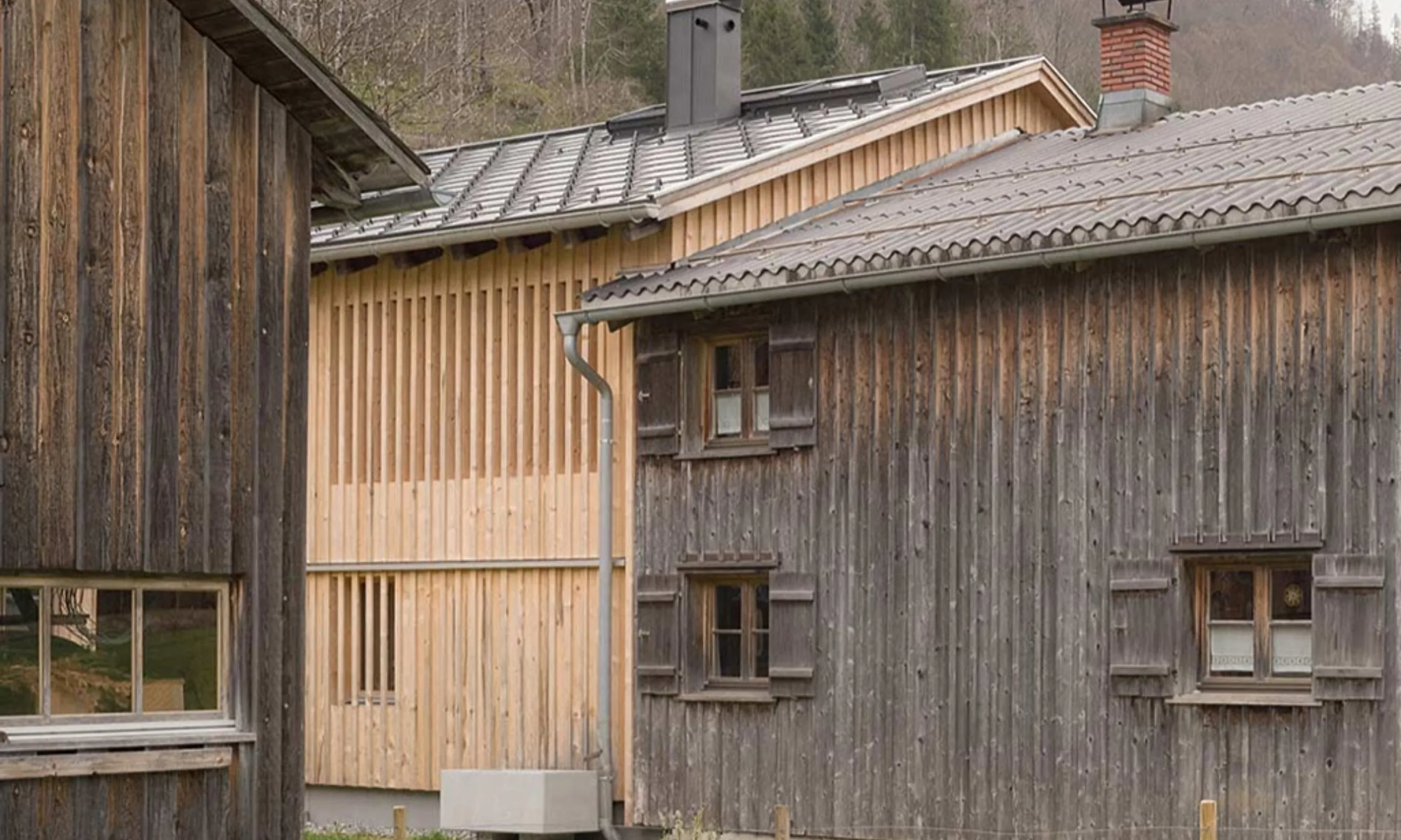 Photo eines Gebäudes mit Holzfassade in einem Garten eigebettet