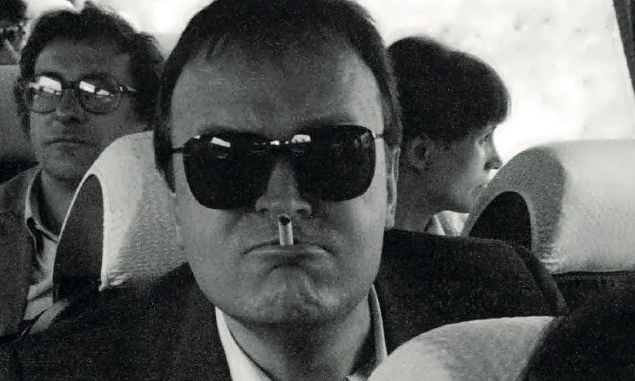 Foto einer Person mit Sonnenbrille und Zigarette im Mund